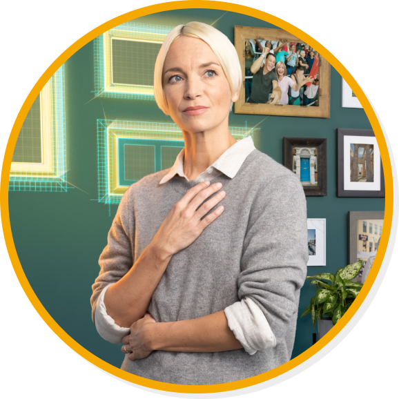 Woman standing in front of wall filled with pictures and a few empty picture frames