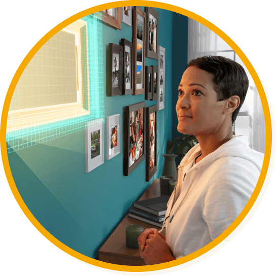 Woman looking at a wall with pictures on it, including an empty picture frame.