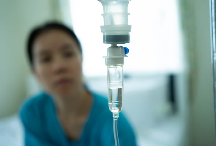 Woman looking at drip from an infusion.