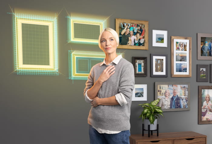 Woman standing in front of wall filled with pictures and a few empty picture frames